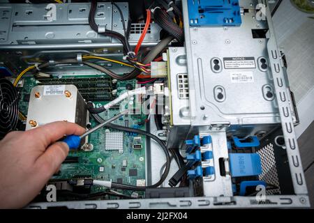 a screwdriver is held in an unscrewed PC Stock Photo