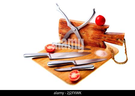 Set of various kitchen knives on wooden cutting boards. Vegetables, salt. Stock Photo