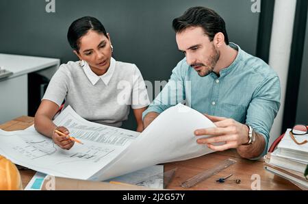 Theyre the pros. Shot of two architects working with blueprints in an office. Stock Photo
