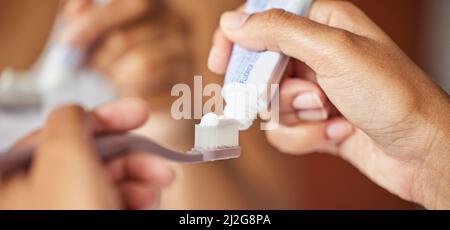 A good dentist never gets on your nerves. Shot of a unrecognizable young woman brushing her teeth in the morning. Stock Photo