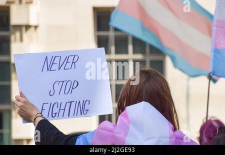 London, United Kingdom. 6th Aug, 2021. A protester holds a 'Never Stop Fighting' sign. Protesters gathered outside Downing Street demanding an end to discrimination against the trans community, better support from the government against hate, and improvements to trans healthcare waiting times. Stock Photo