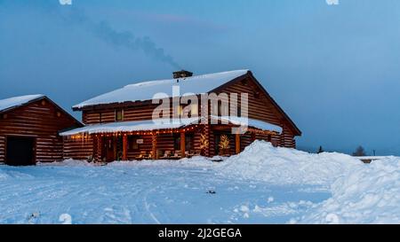 Stanley, ID  USA - 28 Dec 2021: Triangle C Cabins Office Building in the winter Snow Stock Photo