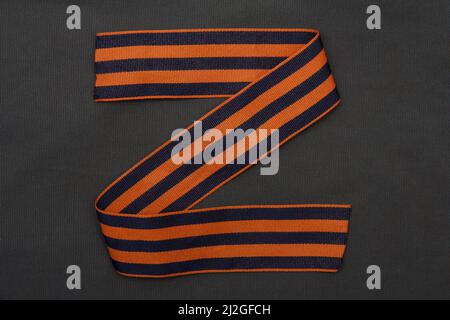 The letter z from the St. George ribbon on a background of green army fabric. Logo Z for Russia. Stock Photo