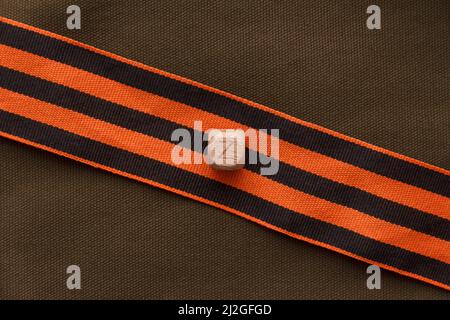 The letter z from the St. George ribbon on a background of green army fabric. Logo Z for Russia. Stock Photo