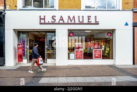 Kingston Upon Thames London UK, April 01 2022, H Samuel High Street Retail Jewellers With Person Walking Past Carrying Shopping Stock Photo