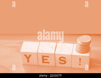 The word Yes written in black letters on wooden blocks. Message spells Yes on red background. Business, motivation and education concept. Stock Photo