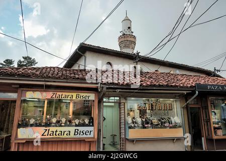 NOVI PAZAR, SERBIA - JULY 25, 2017: showcases of shops specialise in gold jewellery under the minaret of Arap Mosque in dowtown Stock Photo