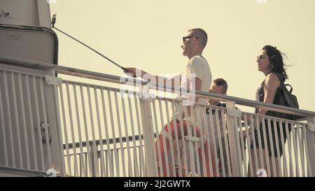 BARI, ITALY - JULY 17, 2017: on the ferry boat unidentified family taking selfie using a pole to take a picture with smartphone Stock Photo