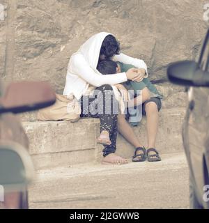 OSTROG MONASTERY, MONTENEGRO - JULY 19, 2017: mother consoling the young son with a hug Stock Photo