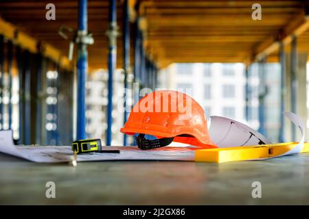 Blueprints project building, construction level and helmet, close up. Construction concept. Stock Photo