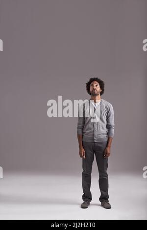 Ive got my sights set on the top. Studio shot of a handsome young man isolated on gray. Stock Photo