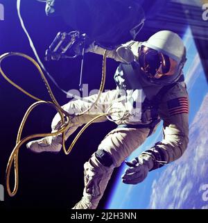 On June 3, 1965 Edward H. White II became the first American to step outside his spacecraft and let go, effectively setting himself adrift in the zero gravity of space. For 23 minutes White floated and maneuvered himself around the Gemini spacecraft while logging 6500 miles during his orbital stroll. White was attached to the spacecraft by a 25 foot umbilical line and a 23-ft. tether line, both wrapped in gold tape to form one cord. In his right hand White carries a Hand Held Self Maneuvering Unit (HHSMU) which is used to move about the weightless environment of space. The visor of his helmet Stock Photo