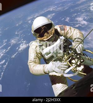 On June 3, 1965 Edward H. White II became the first American to step outside his spacecraft and let go, effectively setting himself adrift in the zero gravity of space. For 23 minutes White floated and maneuvered himself around the Gemini spacecraft while logging 6500 miles during his orbital stroll. White was attached to the spacecraft by a 25 foot umbilical line and a 23-ft. tether line, both wrapped in gold tape to form one cord. In his right hand White carries a Hand Held Self Maneuvering Unit (HHSMU) which is used to move about the weightless environment of space. The visor of his helmet Stock Photo