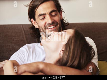 Arent they adorable. Shot of a young couple relaxing on the couch at home. Stock Photo