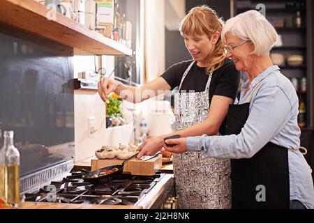 Learning from master chef. Shot of a senior woman and a younger woman cooking together. Stock Photo