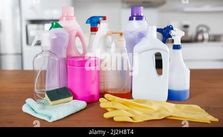 The spring cleaning starter pack. Shot of various cleaning products on a table in the kitchen at home. Stock Photo
