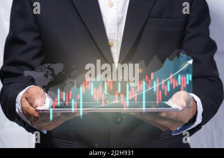 world market trading concept with digital tablet in the human hand and digital finance chart and world map on dark background with copy space. virtual Stock Photo