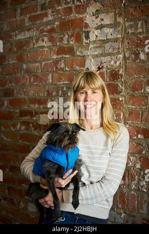 Portrait of smiling mature woman holding dog Stock Photo