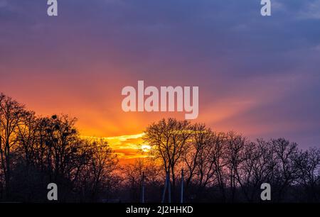 Sun beams in the dark sky at sunset. Stock Photo