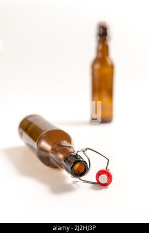 Empty beer bottle with swing top or flip top cork lying on white background. Artistic view, very shallow focus Stock Photo