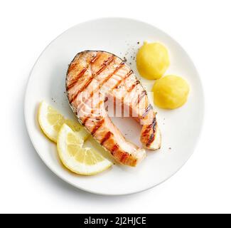 plate of grilled salmon steak and potato isolated on white background, top view Stock Photo