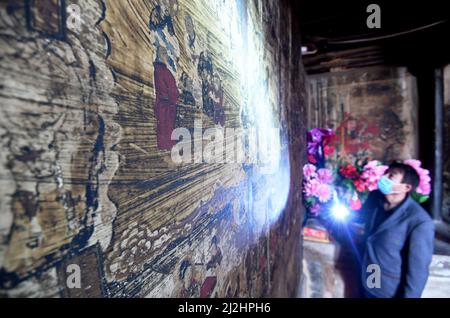 ZHANGJIAKOU, CHINA - APRIL 2, 2022 - Cultural relics workers survey a mural in an ancient building in Zhangjiakou city, North China's Hebei Province, Stock Photo