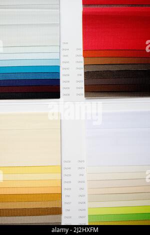 Samples of fabrics of different textures and colors in the form of a catalog for the selection of fabrics for fabric blinds Stock Photo