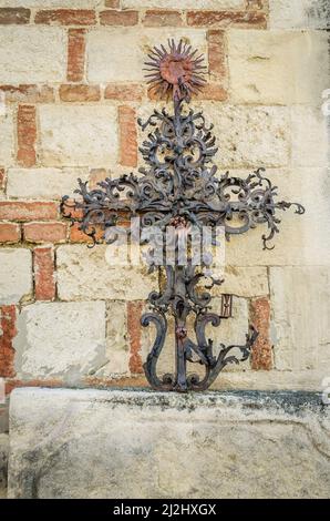 Forged steel cross, leaning against the church wall in the courtyard. Serbian Orthodox Church in Sremska Kamenica - Church of the Nativity of the Most Stock Photo