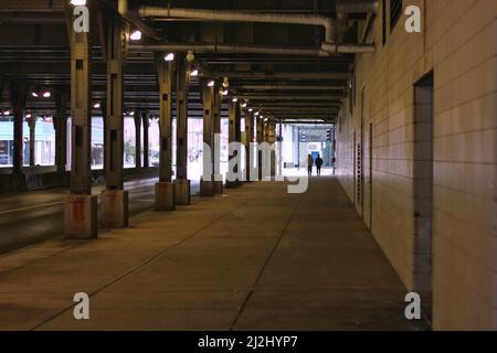 Two people walking under Chicago's downtown Ogilvie train station Stock