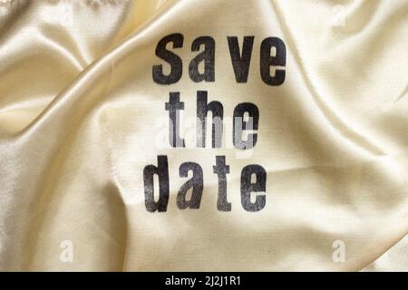 Save the date written on golden satin fabric Stock Photo