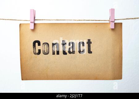 Contact written on vintage yellowed paper isolated on white Stock Photo