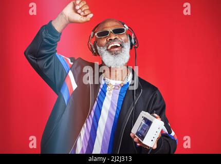 Music is what keeps me feeling young. Shot of a mature man listening to music through headphones. Stock Photo
