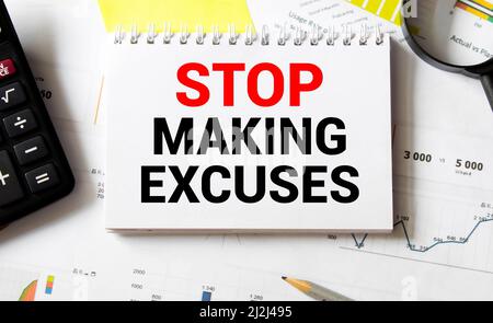 Business concept. Notebook with text STOP MAKING EXCUSES sheet of white paper for notes, calculator, glasses, pencil, pen, in the white background Stock Photo