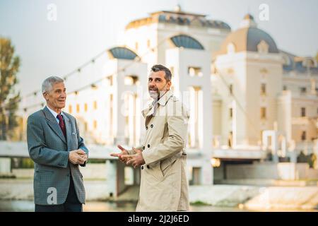 Two amazing senior businessmen are talking and looking away, close up Stock Photo