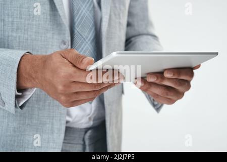 The gadget that keeps me one step ahead of the rest. Cropped shot of an unrecognizable businessman using a digital tablet. Stock Photo