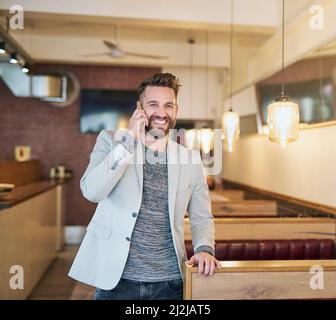 Im just leaving.... Cropped shot of a modern businessman using his cellphone in a coffee shop. Stock Photo