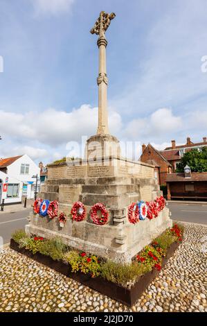 The war memorial with red poppy wreaths in the market square of Holt, a small historic Georgian market town in north Norfolk, England, on a sunny day Stock Photo