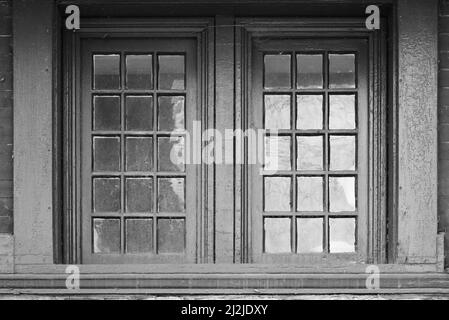 Vintage wooden windows on a charming rustic stone cottage in black and white. Stock Photo