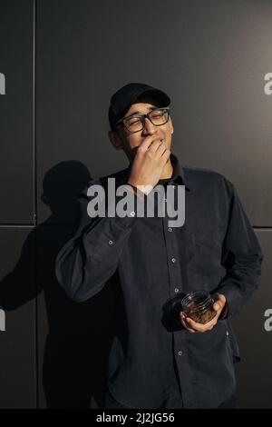 happy african american man holding metal scoop with raisins Stock Photo
