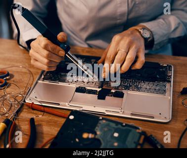 Putting the pieces back together. Cropped shot of an unrecognizable female computer technician repairing a laptop in her workshop. Stock Photo