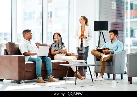 Inspired to keep on producing greatness. Shot of a group of businesspeople having a discussion in an office. Stock Photo