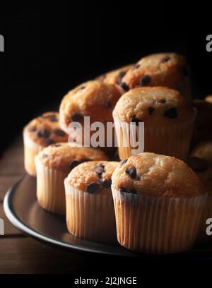 Dark food macro photography, vanilla cupcakes with chocolate chips, concept of homemade desserts. Stock Photo