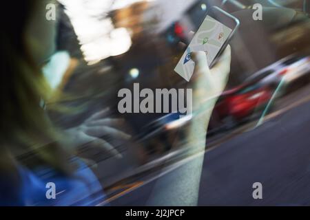 Looking for directions Theres an app for that. Cropped shot of a woman using her phones gps while driving. Stock Photo