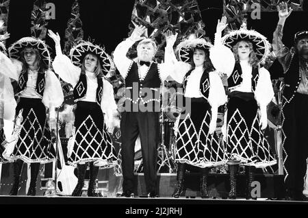 Benny Hill, British comedian and actor, best known for his television programme The Benny Hill Show, in America, where he is filming a one hour special, Benny Hill's World Tour : New York, which will be shot on location in New York City, Saturday 28th March 1987. Our Picture Shows ... Benny Hill performing on stage with Hill's Angels. Stock Photo