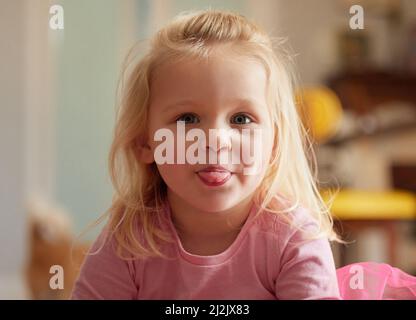 Catch me if you can. Shot of an adorable little girl sticking her tongue out. Stock Photo