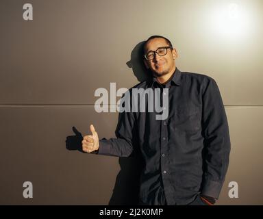 All Is Great. Cheerful Black Millennial Guy Showing Thumbs Up At Camera, Positive African American Hipster Man Gesturing Sign Of Approval Stock Photo