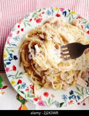 Overhead view of homemade tagliatelle carbonara on a floral plate Stock Photo