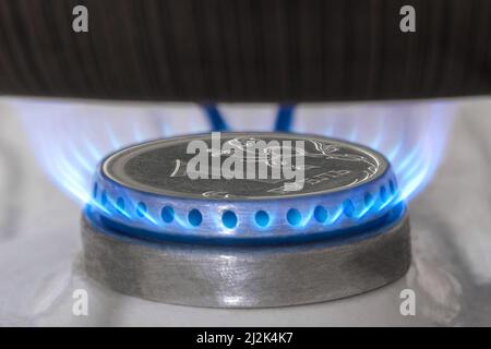 Gas burner and ruble coin, Russian money on home gas stove. Blue propane gas flame and ruble currency. Concept of Russia and Europe economy, natural g Stock Photo