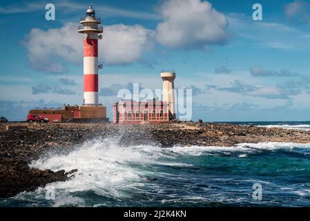 Waves crashing against rocky coastline by Toston lighthouse, El Cotillo, Fuerteventura, Canary Islands, Spain Stock Photo