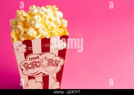 Red and White Striped Popcorn Bucket Isolated on a Pink Background Stock Photo